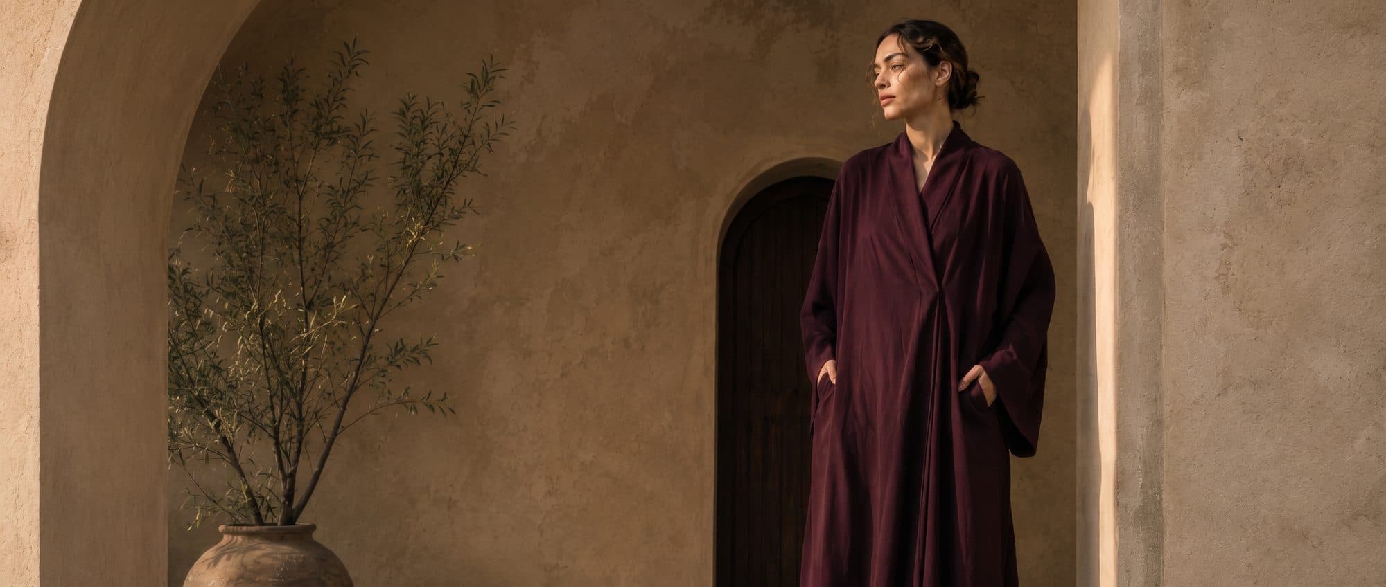 An oxblood abaya in an archway